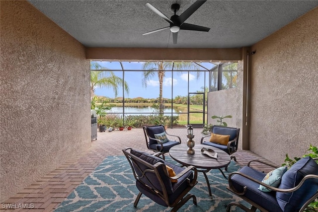 sunroom / solarium with ceiling fan, a water view, and plenty of natural light