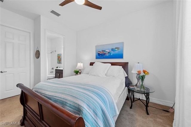 bedroom with light carpet, ensuite bathroom, and ceiling fan