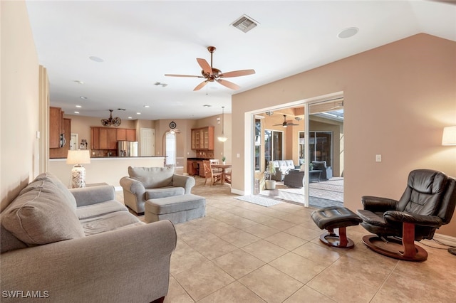 living room with ceiling fan, light tile patterned floors, and lofted ceiling