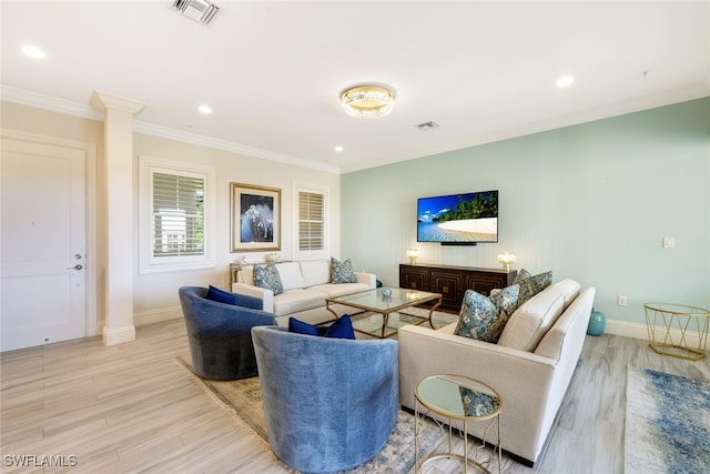 living room with decorative columns, light hardwood / wood-style floors, and ornamental molding