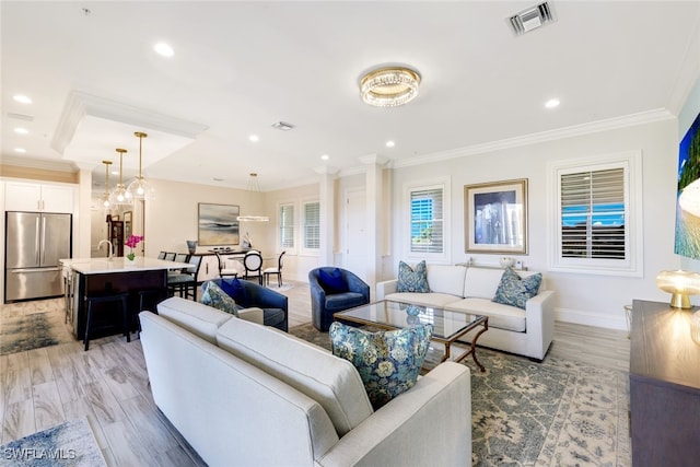 living room featuring light hardwood / wood-style floors, crown molding, and sink