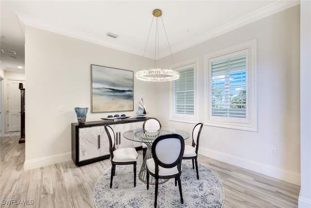 dining room with an inviting chandelier, ornamental molding, and light hardwood / wood-style flooring