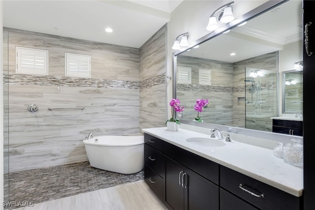 bathroom featuring crown molding, vanity, tile walls, and shower with separate bathtub