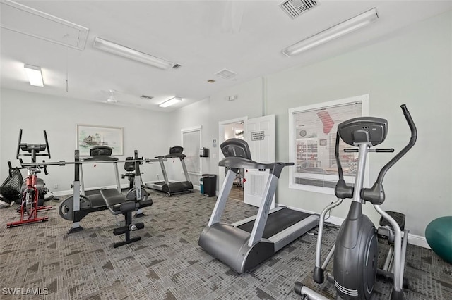 exercise room featuring attic access, visible vents, carpet floors, and baseboards