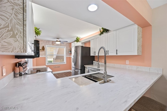 kitchen featuring white cabinets, electric stove, ceiling fan, stainless steel refrigerator with ice dispenser, and a sink