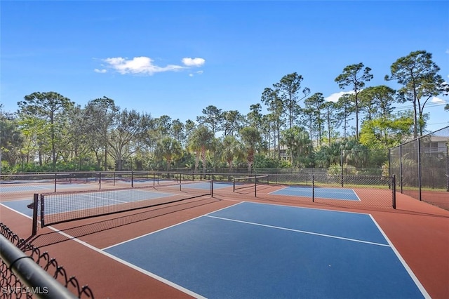 view of tennis court with community basketball court and fence