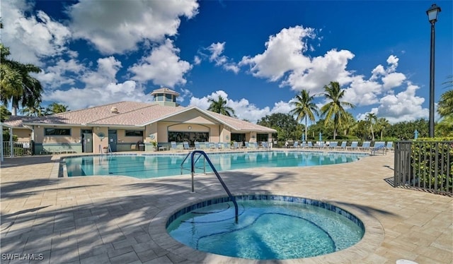 view of swimming pool featuring a community hot tub and a patio