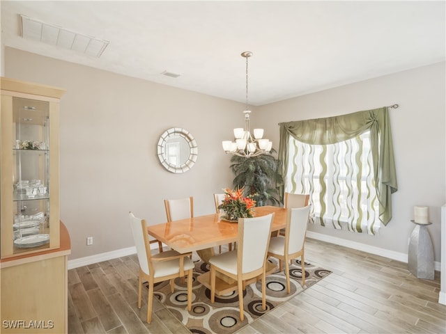 dining space featuring hardwood / wood-style floors and a notable chandelier