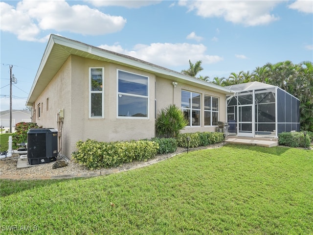 rear view of property featuring cooling unit, a lanai, and a lawn