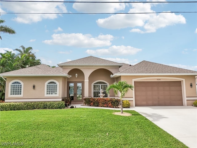 view of front of house featuring french doors, a front lawn, and a garage