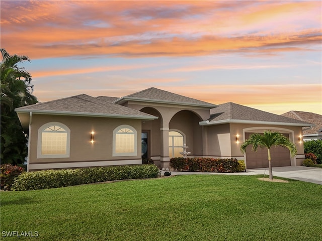 prairie-style home featuring a garage and a lawn