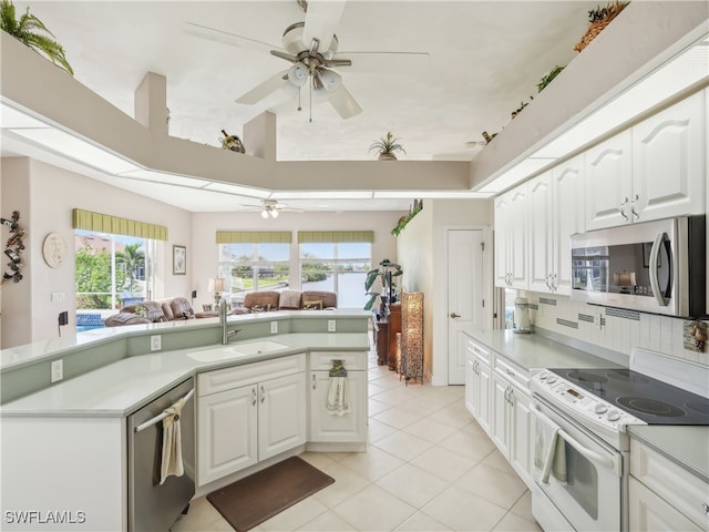 kitchen with white cabinets, stainless steel appliances, light tile patterned flooring, and sink