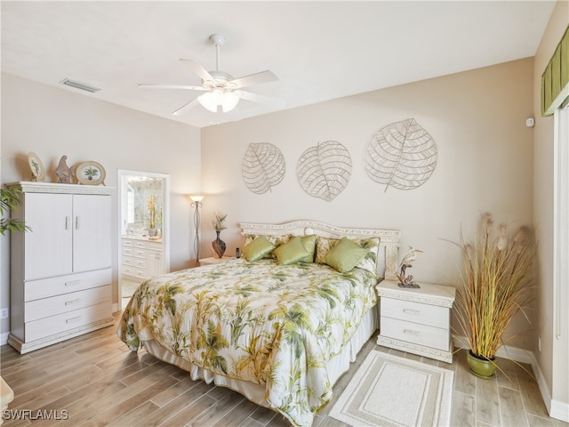 bedroom featuring ceiling fan, light wood-type flooring, and ensuite bath