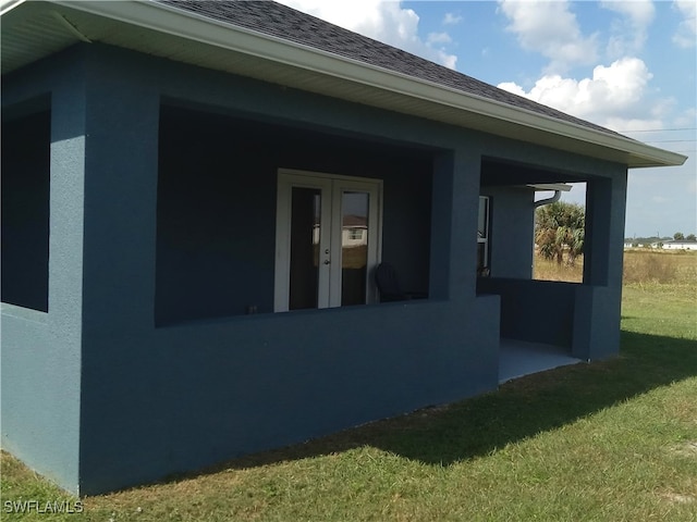 view of property exterior featuring a lawn and french doors