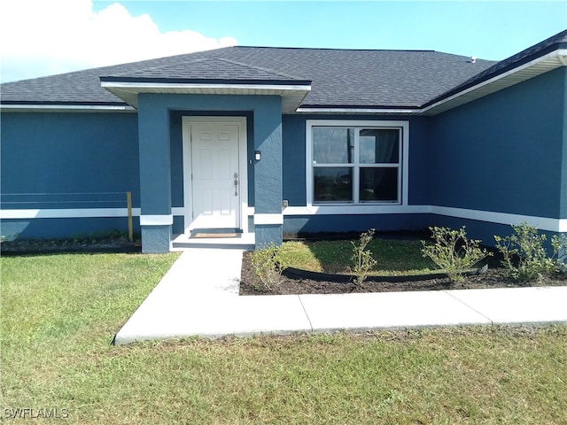 property entrance with a lawn