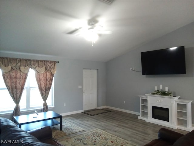 living room with ceiling fan, hardwood / wood-style floors, and vaulted ceiling