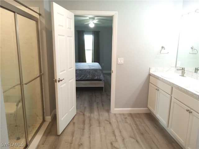 bathroom featuring hardwood / wood-style flooring, ceiling fan, an enclosed shower, and vanity