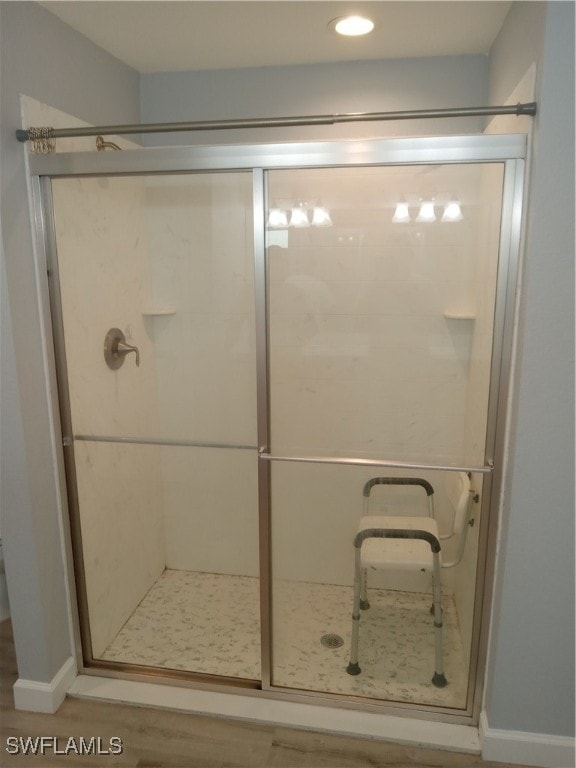 bathroom featuring wood-type flooring and walk in shower