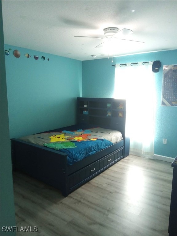 bedroom with ceiling fan and wood-type flooring