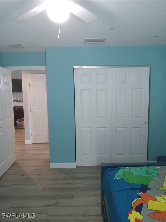 bedroom with wood-type flooring, a closet, and ceiling fan