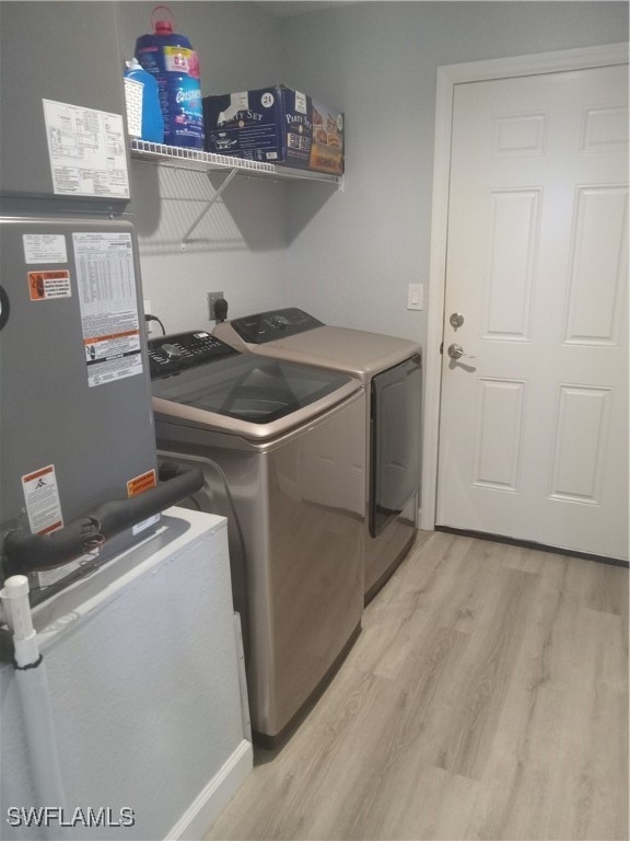 laundry area featuring washer and dryer and light hardwood / wood-style floors