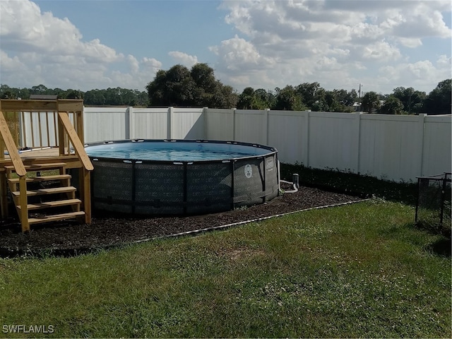 view of swimming pool featuring a deck and a yard