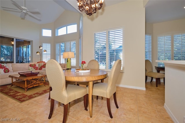 tiled dining room with ceiling fan with notable chandelier and high vaulted ceiling