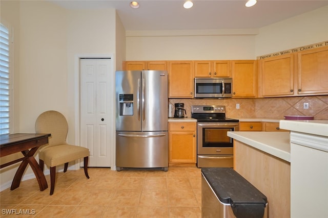 kitchen featuring decorative backsplash, light tile patterned flooring, stainless steel appliances, and light brown cabinetry