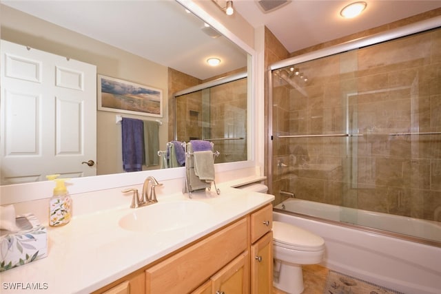 full bathroom with vanity, combined bath / shower with glass door, and toilet