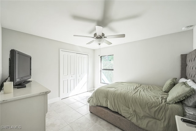 tiled bedroom featuring ceiling fan and a closet