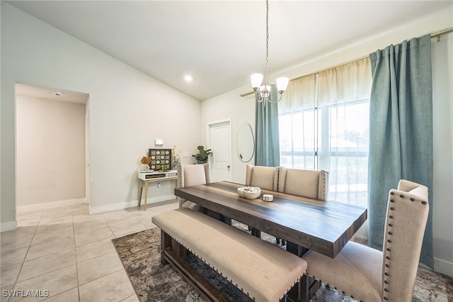 dining area featuring a notable chandelier, lofted ceiling, and light tile patterned floors