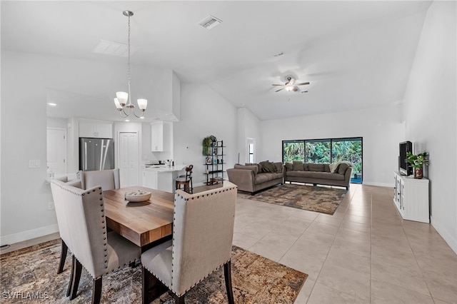 dining room featuring light tile patterned floors, high vaulted ceiling, and ceiling fan with notable chandelier