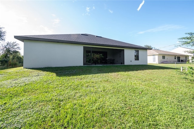 rear view of property featuring a yard