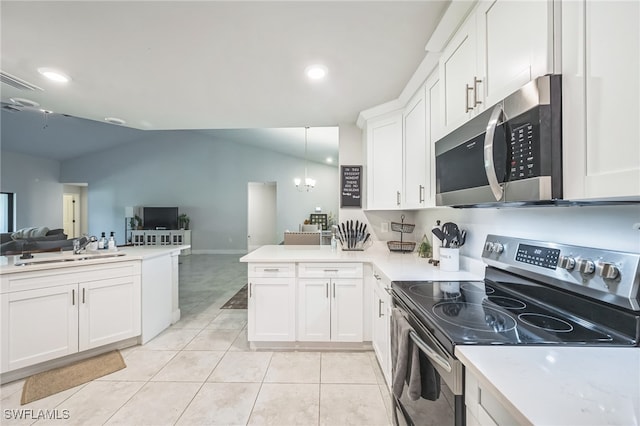 kitchen featuring pendant lighting, lofted ceiling, kitchen peninsula, and appliances with stainless steel finishes