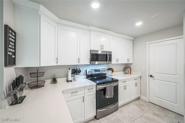 kitchen with light tile patterned flooring, white cabinetry, and appliances with stainless steel finishes