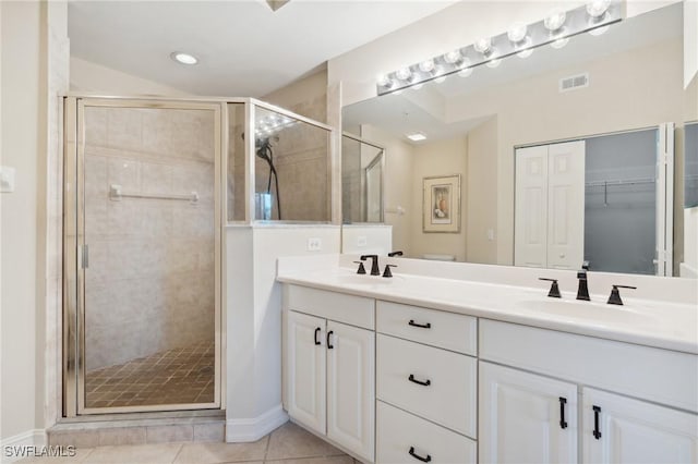 bathroom featuring tile patterned floors, visible vents, a shower stall, and a sink