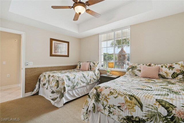 bedroom featuring a raised ceiling and ceiling fan