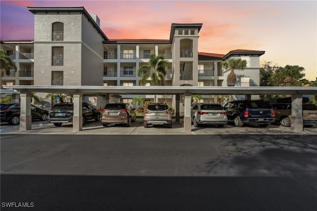 property at dusk featuring covered parking