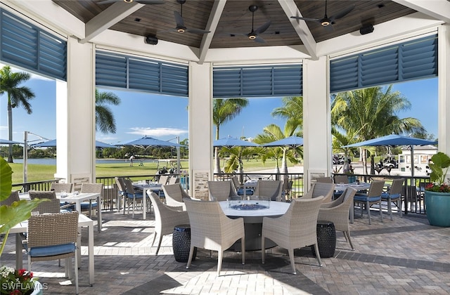 view of patio featuring ceiling fan, a gazebo, and outdoor dining space