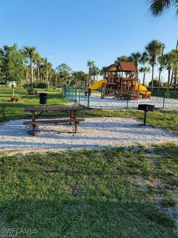 view of property's community featuring fence and playground community