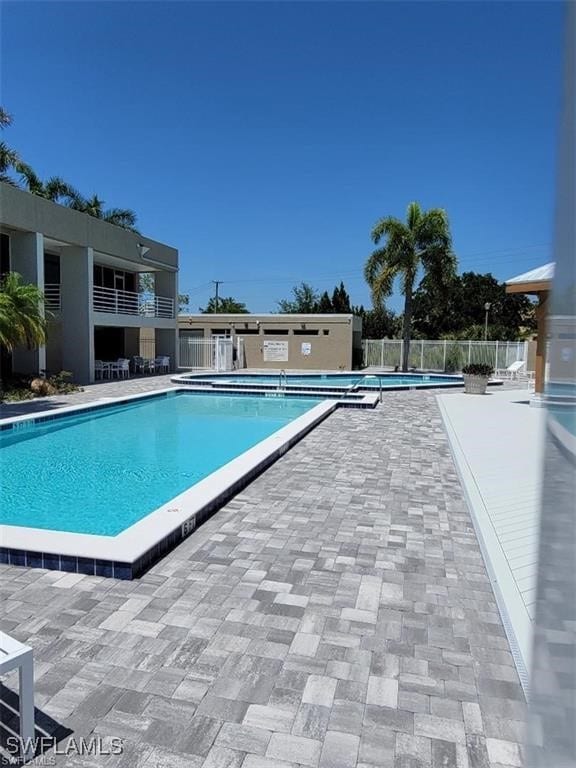 pool featuring fence and a patio
