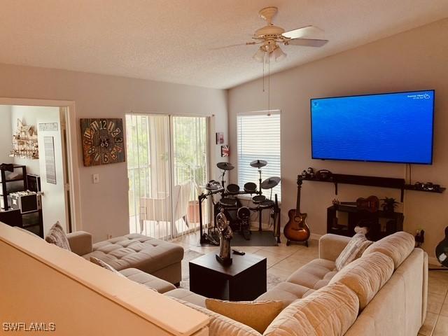 tiled living room with ceiling fan and a textured ceiling