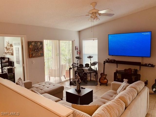 living area featuring light tile patterned floors and ceiling fan