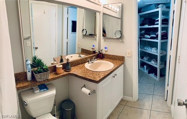 bathroom with tile patterned floors, baseboards, vanity, and toilet