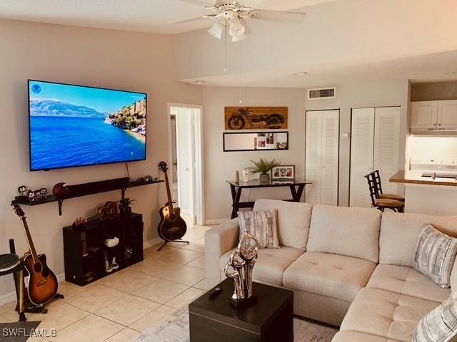 tiled living room featuring lofted ceiling and ceiling fan