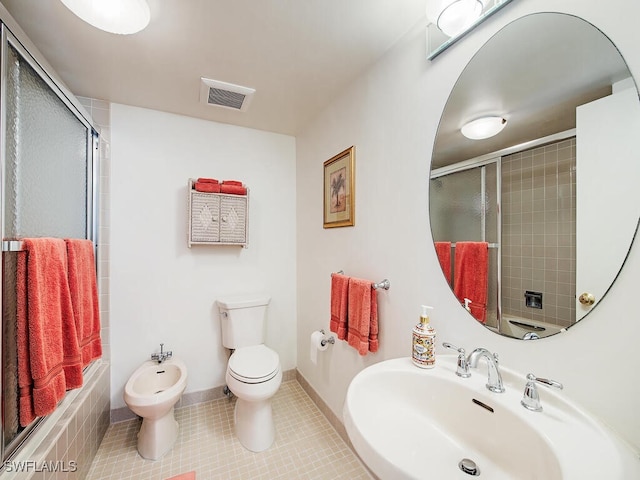 bathroom with tile patterned floors, sink, a bidet, and toilet