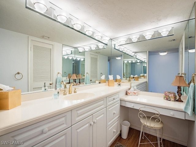 bathroom featuring hardwood / wood-style floors, vanity, and a textured ceiling