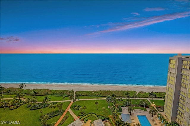 aerial view at dusk with a view of the beach and a water view