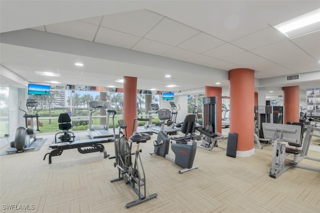 workout area with carpet flooring and a drop ceiling