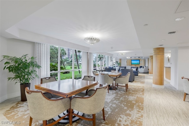 dining space with light wood-type flooring and decorative columns